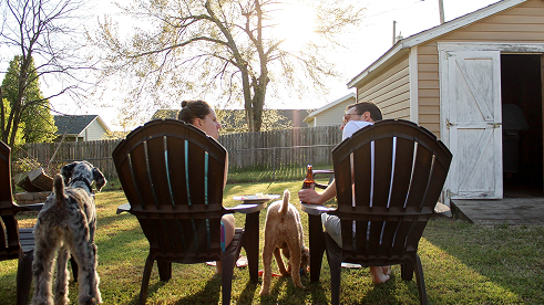 couple and dogs lounging at the lawn